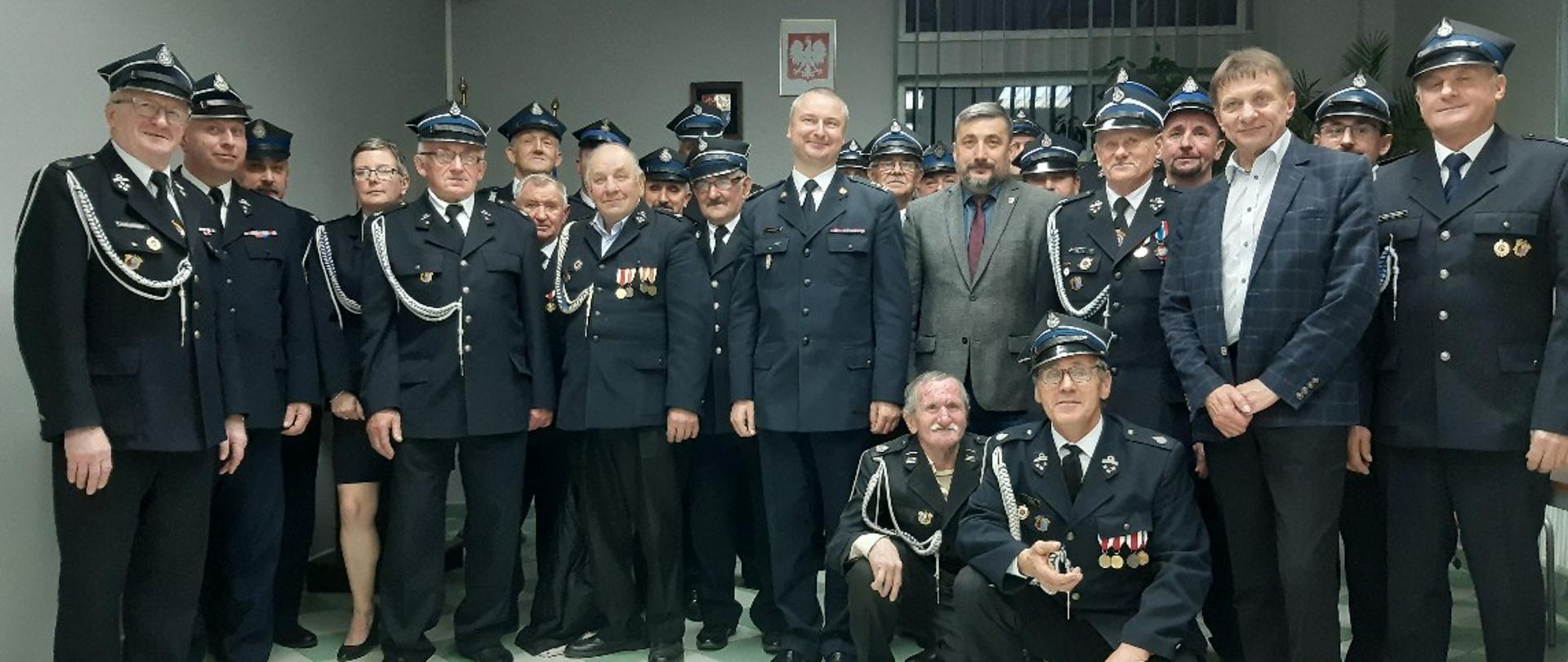 Zdjęcie przedstawia mężczyzn i kobietę w umundurowaniu strażackim - uczestników Zjazdu Oddziału Gminnego ZOSP RP w Zakrzewie. 