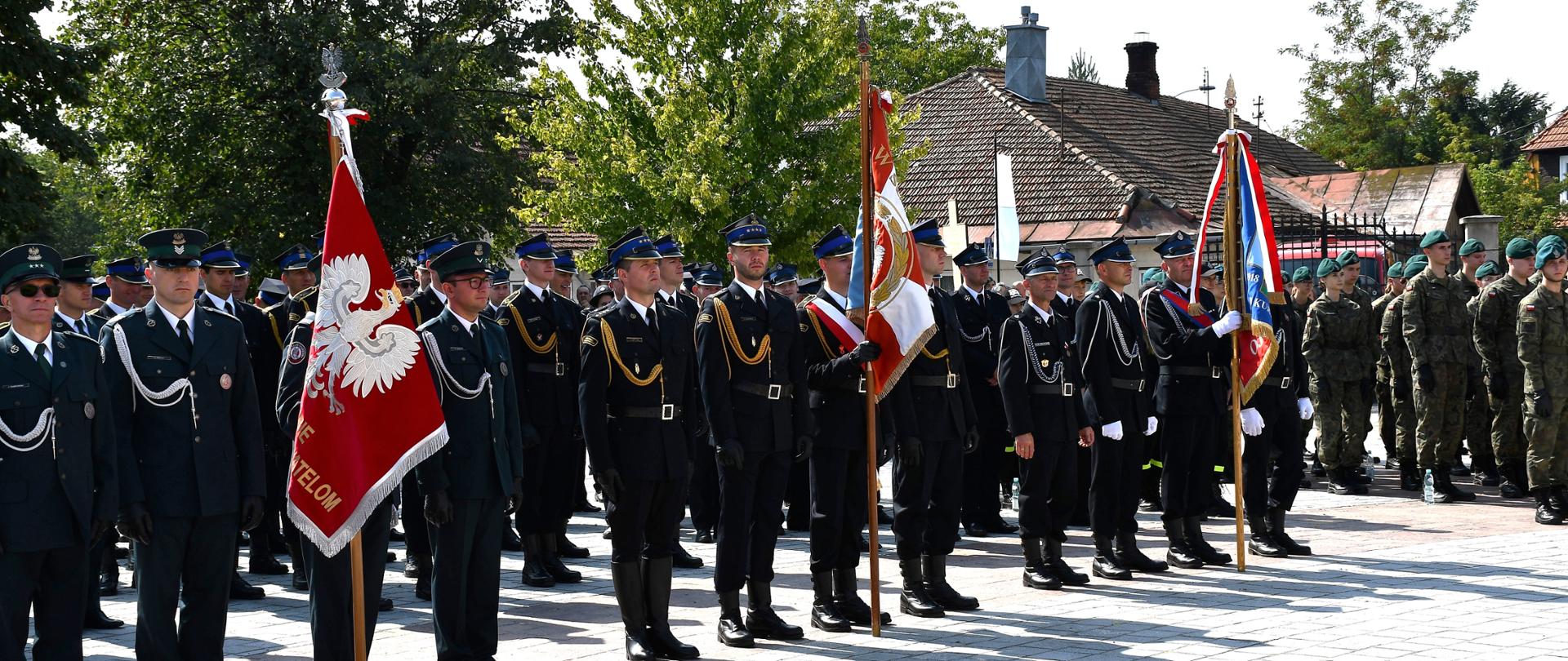 Na zdjęciu widzimy służby mundurowe w tym strażaków stojących na placu bazyliki w Leżajsku.