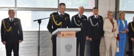 Na zdjęciu widoczny przy mównicy bryg. Andrzej Wróbel - Komendant Powiatowy PSP w Oleśnie. Na drugim planie widoczni: Zastępca Opolskiego Komendanta Wojewódzkiego PSP i zaproszeni goście.