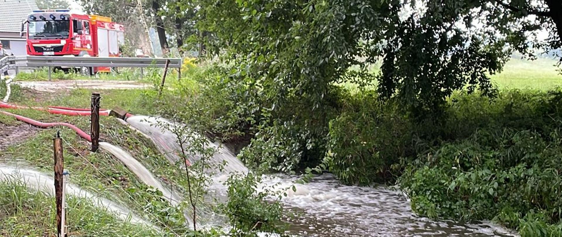 Strażacy wypompowują wodę z zalanej posesji przy użyciu specjalnych pomp