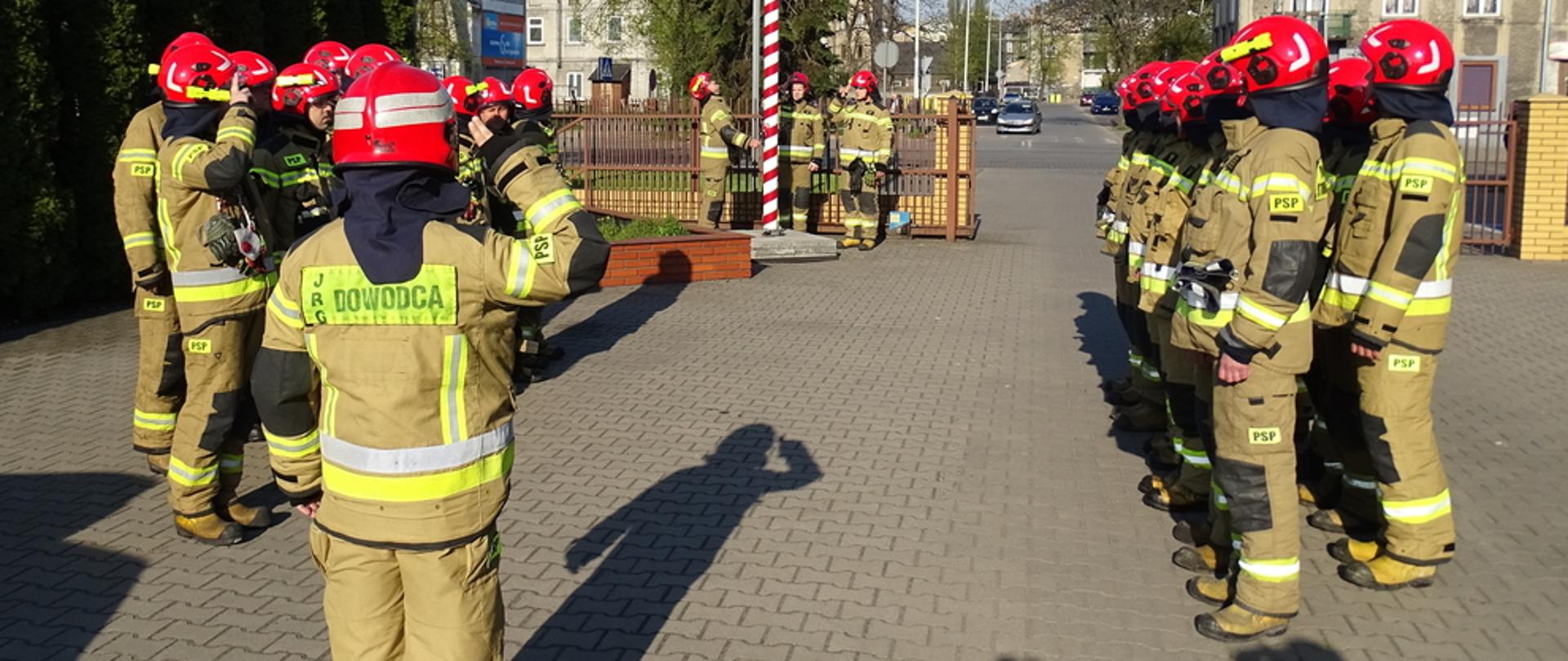 Na zdjęciu strażacy w umundurowaniu specjalnym podczas uroczystej zmiany służby z okazji Dnia Flagi Rzeczypospolitej Polskiej. 