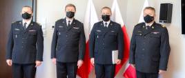 Począwszy od prawej strony stoją w mundurach galowych na tle flag państwowych:
- nadbryg. Jarosław Nowosielski – mazowiecki komendant wojewódzki PSP;
- bryg. Piotr Księżak – p.o. z-ca komendanta powiatowego PSP w Grodzisku Mazowieckim;
- st. bryg. Krzysztof Tryniszewski – komendant powiatowy PSP w Grodzisku Mazowieckim;
- bryg. Marcin Konecki – naczelnik Wydziału Kadr Komendy Wojewódzkiej PSP w Warszawie.

