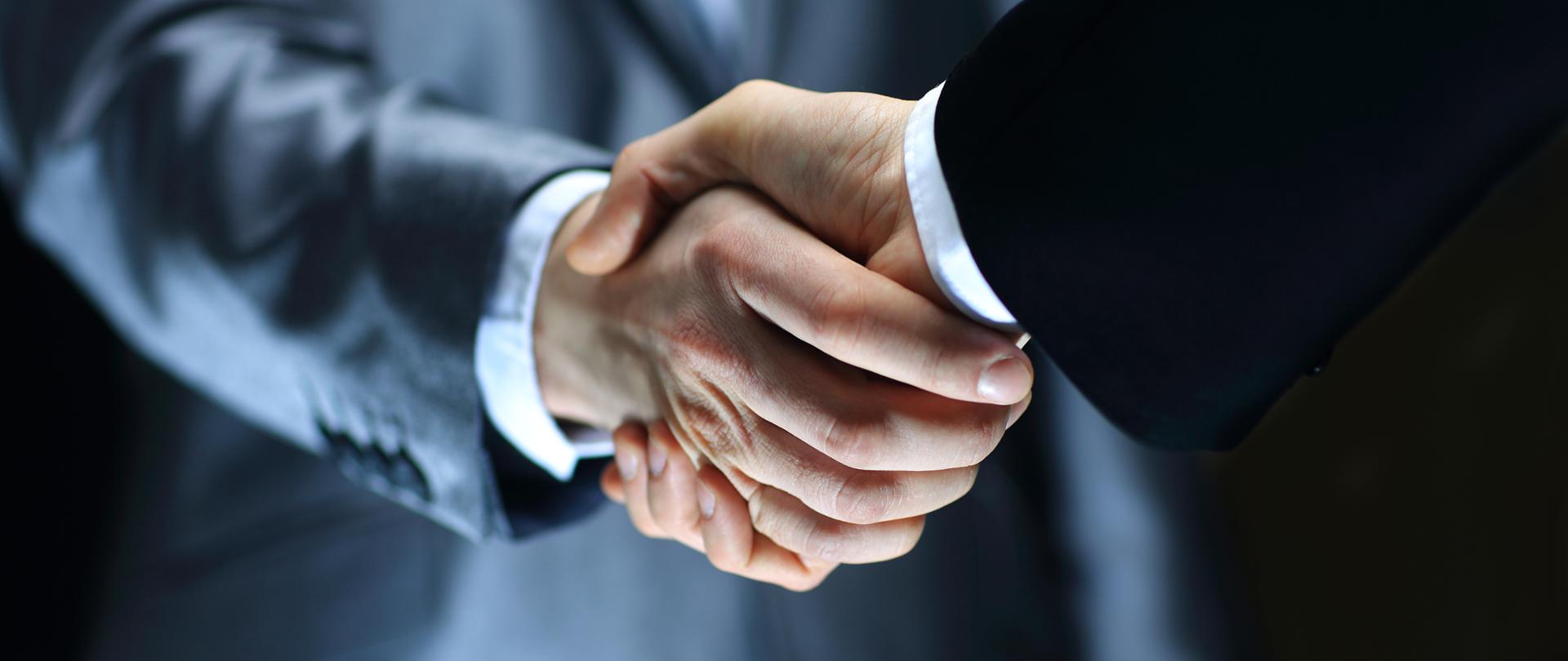 Handshake - Hand holding on black background