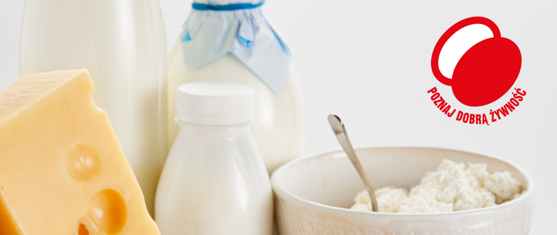 Mleko i jego przetwory w butelkach, ser żółty i twaróg w miseczce. Widoczne jest też logo Poznaj Dobrą Żywność. 