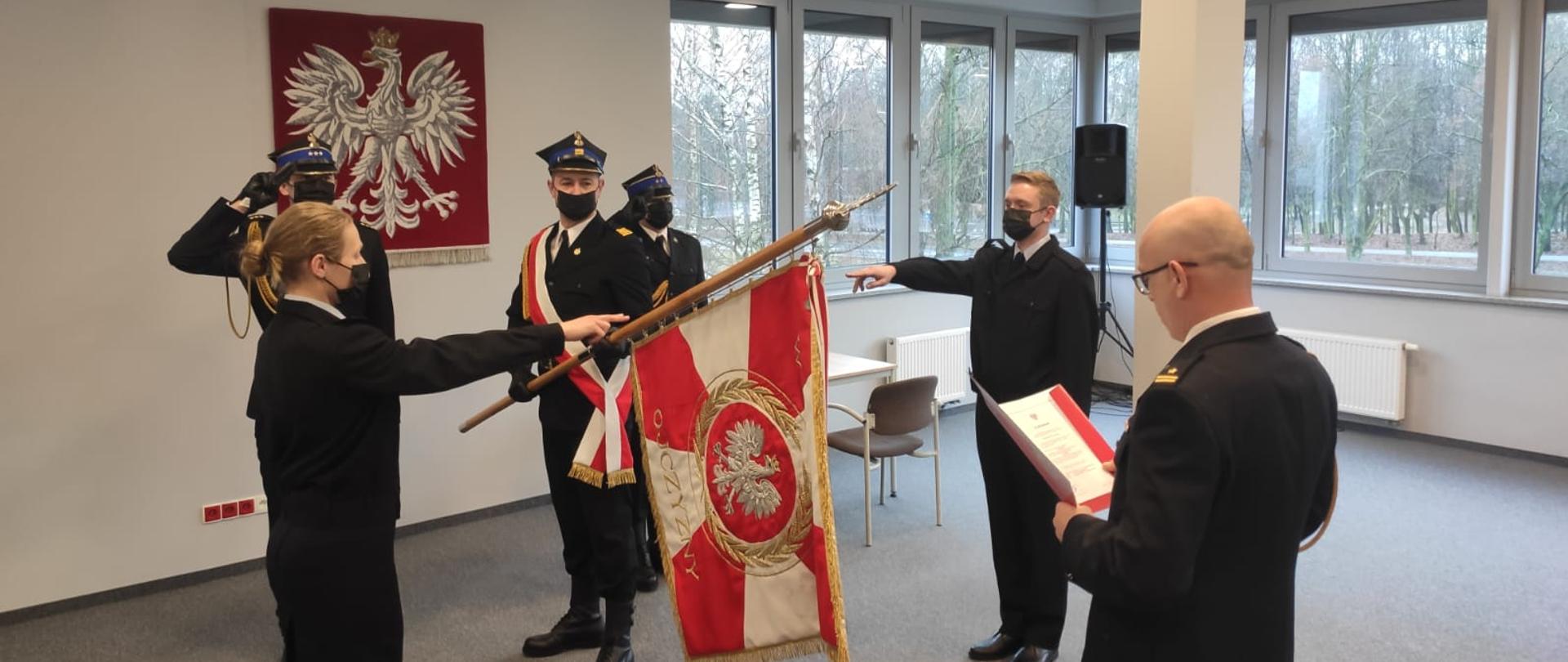 Na zdjęciu strażacy składający ślubowanie na sztandar przed komendantem powiatowym 