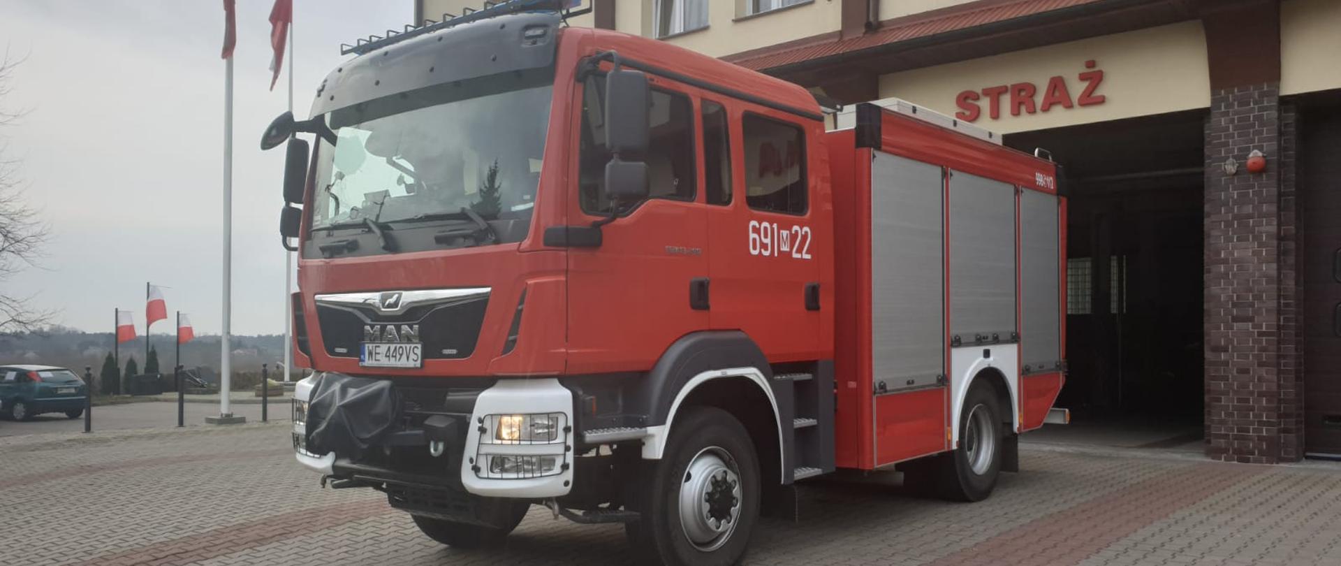 Pojazd strażacki na tle Komendy Powiatowej PSP