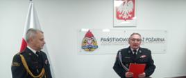 Zdjęcie przedstawia dh Szczepana Kowalika - Komendanta Gminnego Ochotniczych Straży Pożarnych wręczającego upominek przechodzącemu na zaopatrzenie emerytalne bryg. Piotrowi Głodowskiemu.