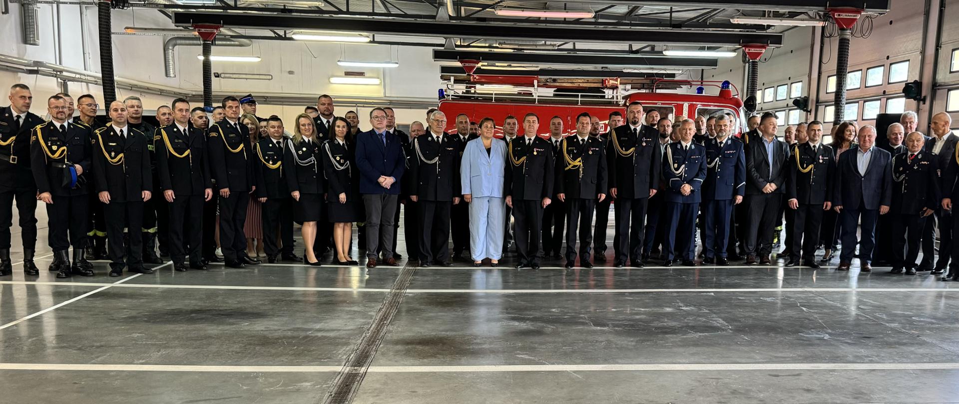 Zdjęcie grupowe gości i strażaków w mundurach galowych
