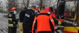 Zdjęcie przedstawia strażaków, ratowników i policjantów umieszczających osobę poszkodowaną w śmigłowcu.