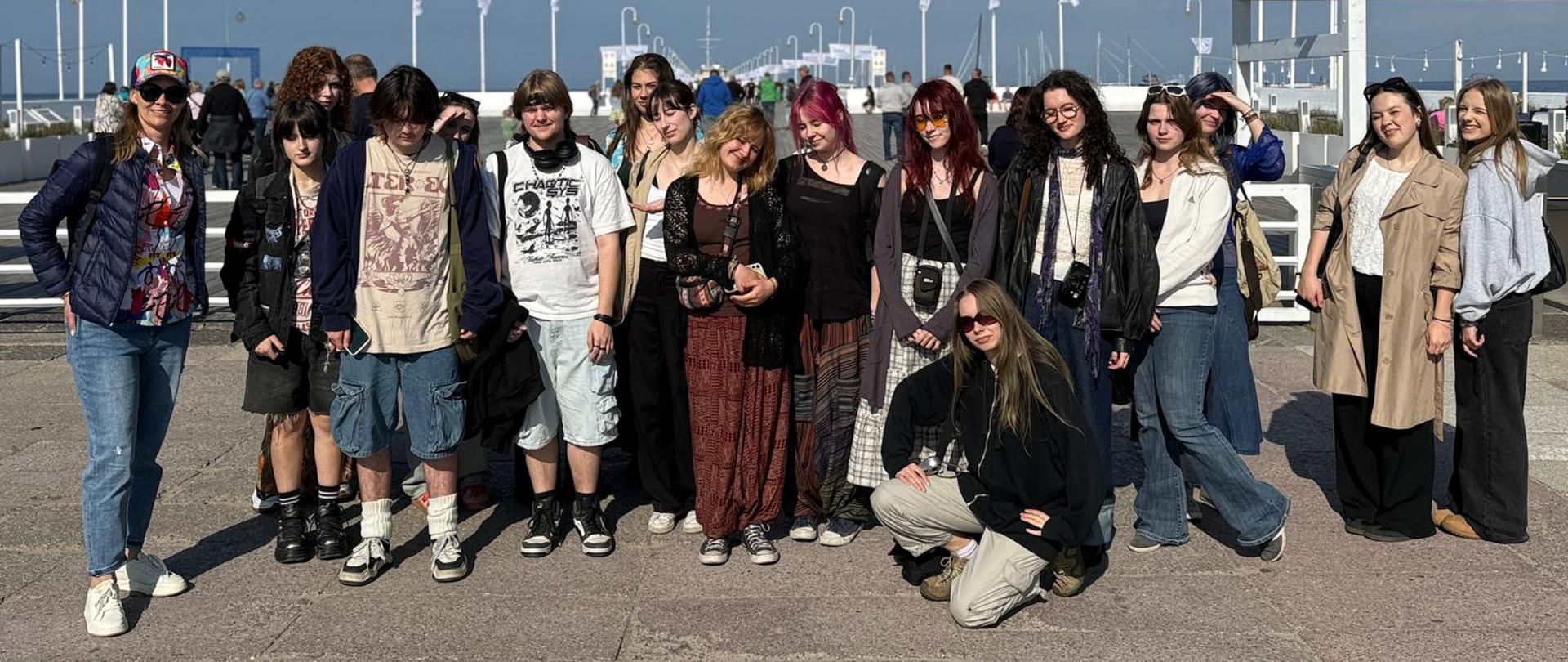 Grupa uśmiechniętych młodych ludzi na tle portu