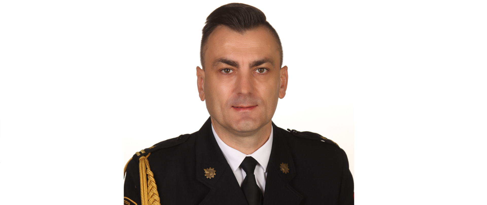 Zdjęcie profilowe Komendanta Powiatowego PSP w Rawie Mazowieckiej mł. bryg. Konrada Krupa na jasnym tle w mundurze galowym.