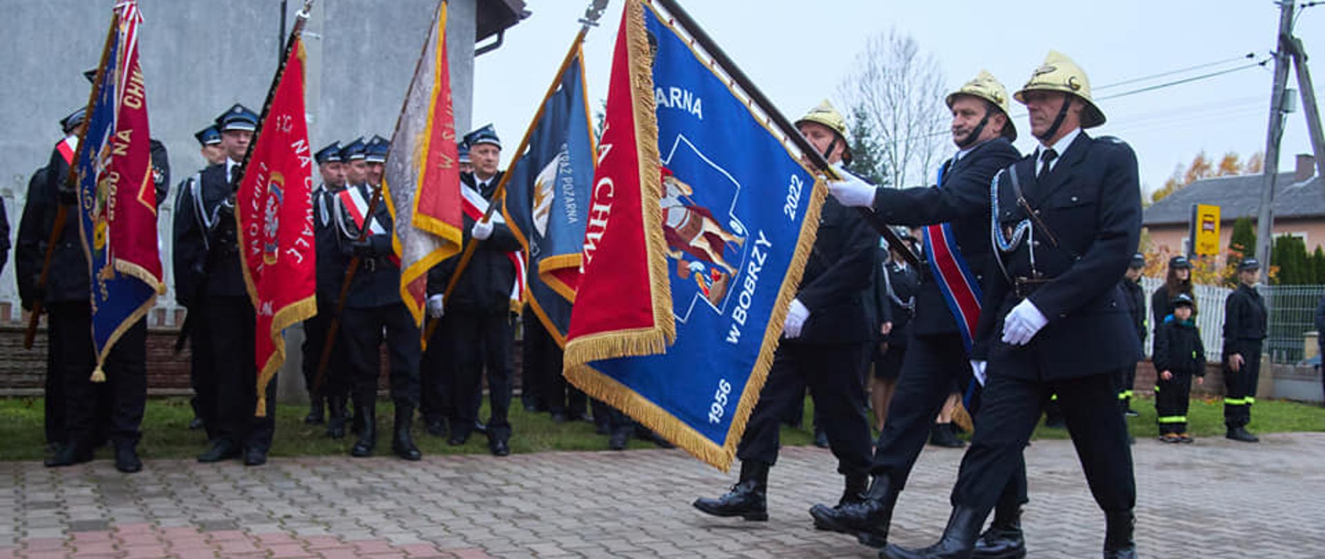 Zdjęcie przedstawia przemarsz pocztu z nowym sztandarem przed druhami.