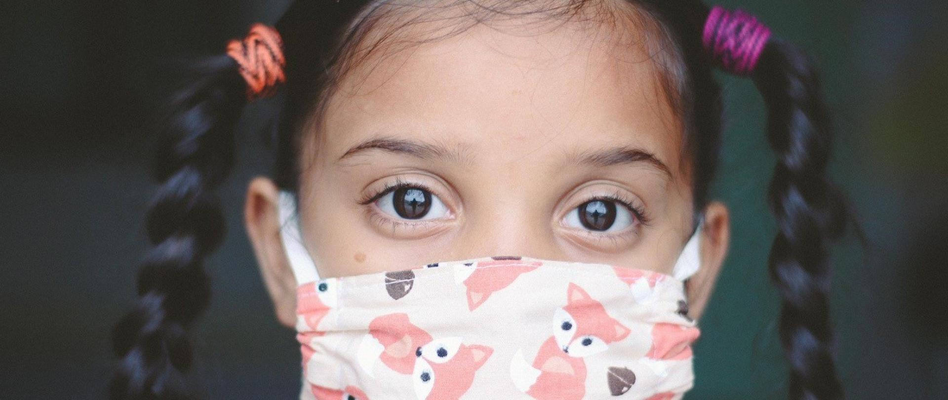 twarz dziewczynki zasłonięta kolorową maseczką ochronną