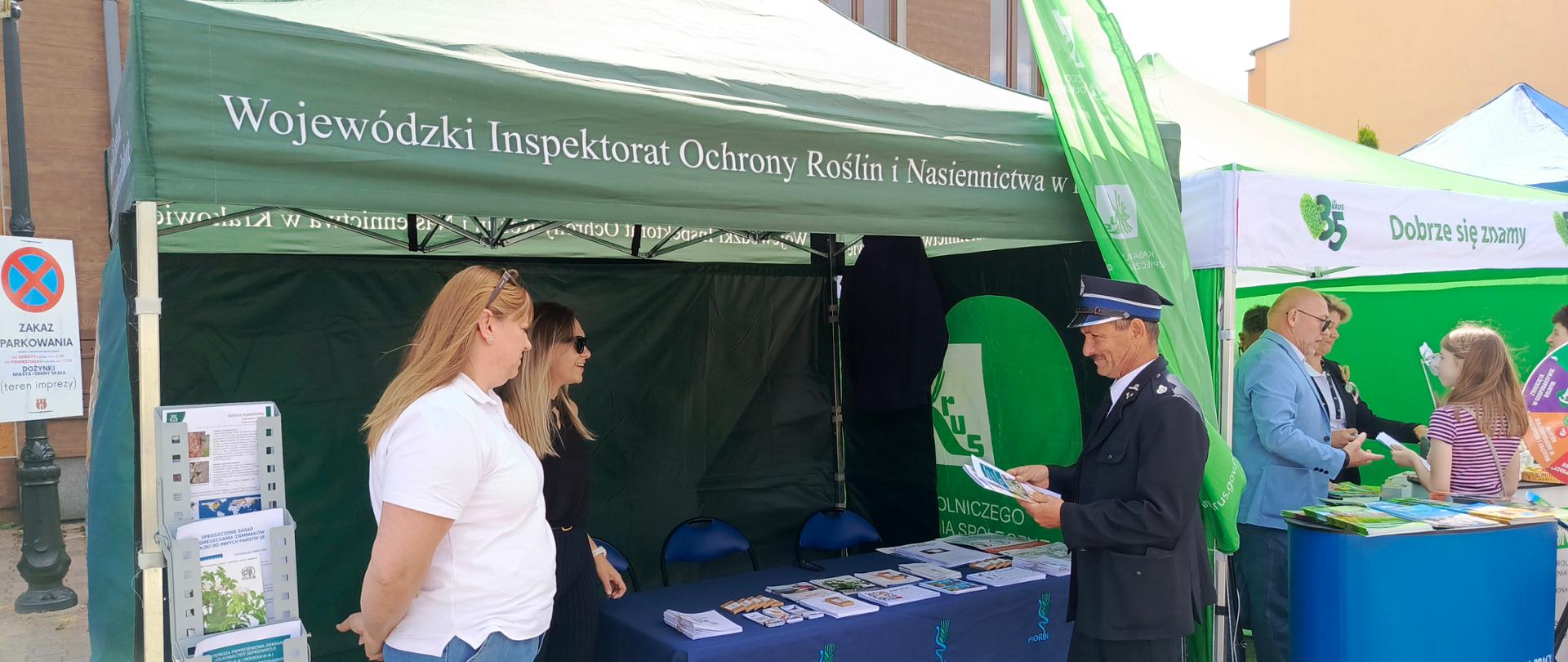 Zielony namiot wystawowy z napisem Wojewódzki Inspektorat Ochrony Roślin i Nasiennictwa w Krakowie i grupa osób