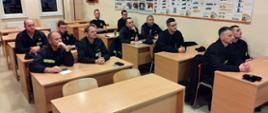 Uczestnicy szkolenia naczelnika OSP siedzą w ławkach w czasie zajęć.