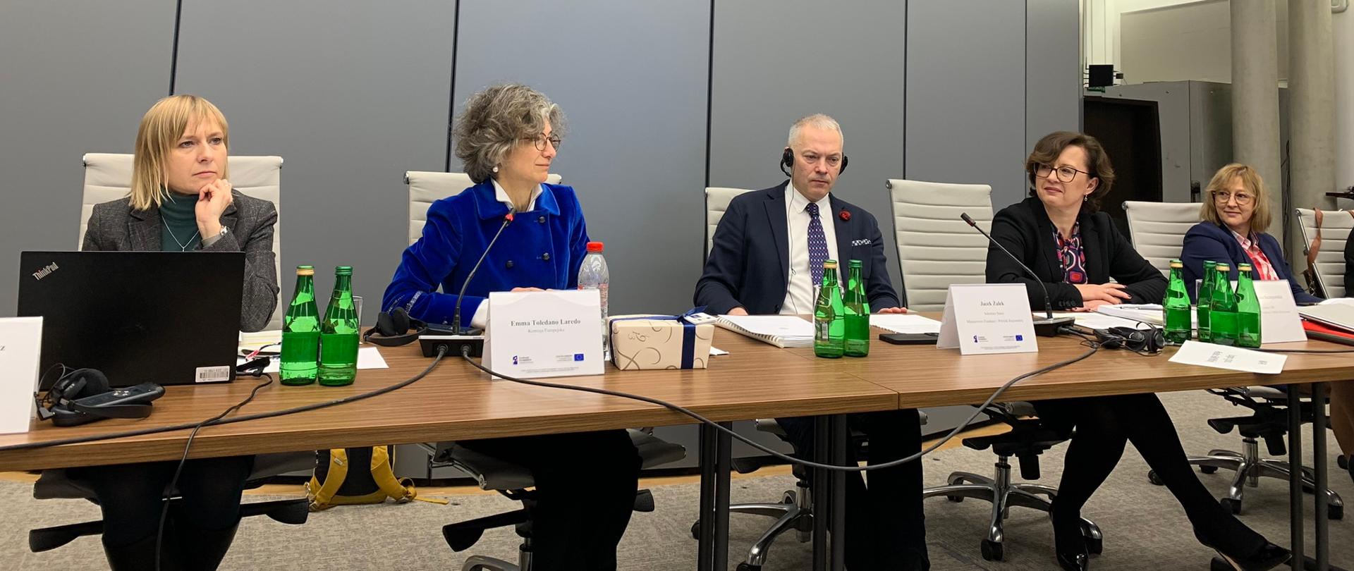 Pięć osób siedzi przy stole