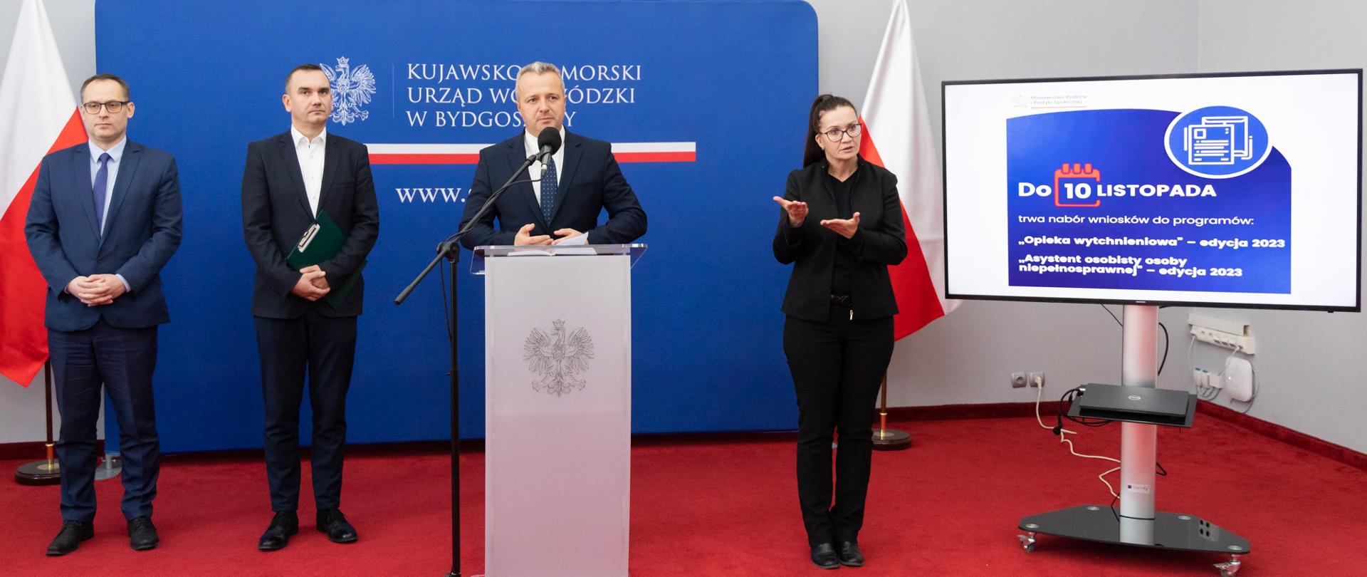 Trzech mężczyzn i kobieta podczas konferencji