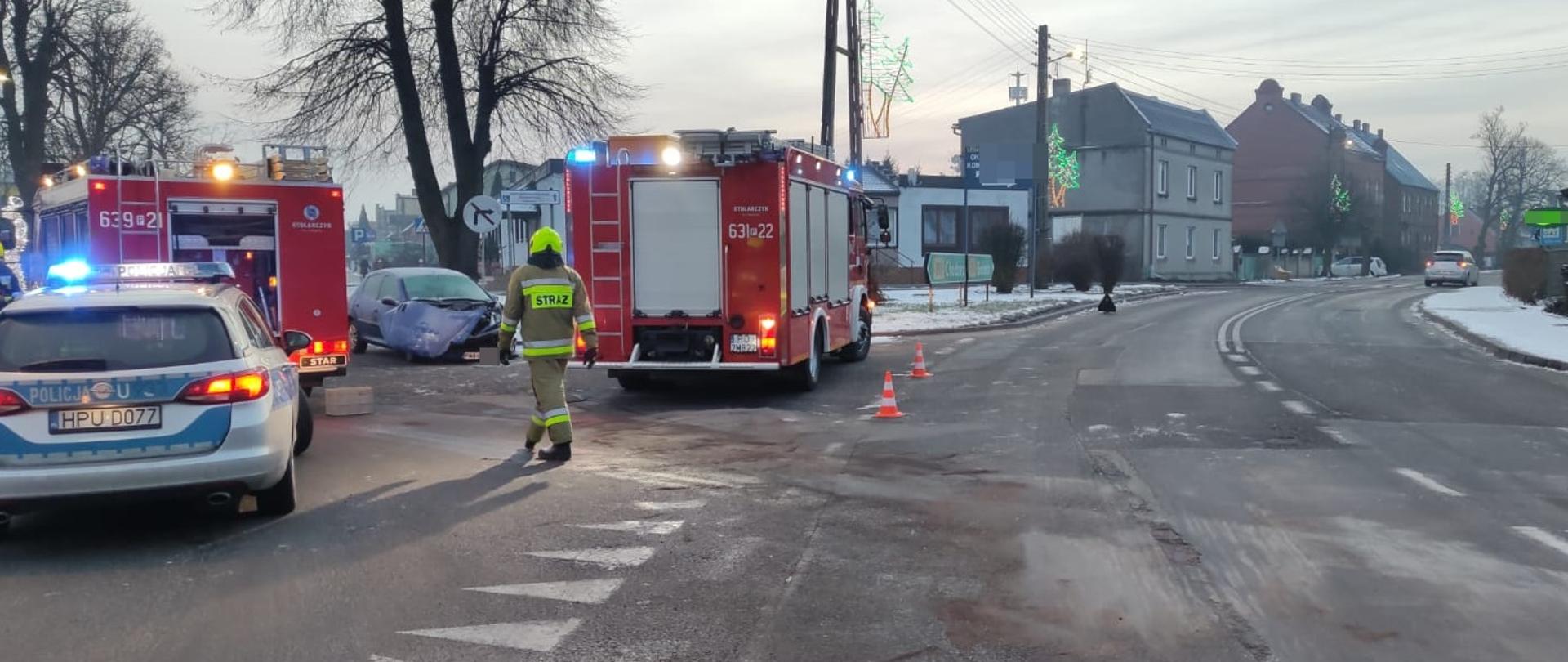 Na zdjęciu widać rozbity pojazd oraz wozy służb ratunkowych 