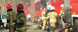 Na zdjęciu strażacy oraz samochody pożarnicze podczas akcji gaśniczej.