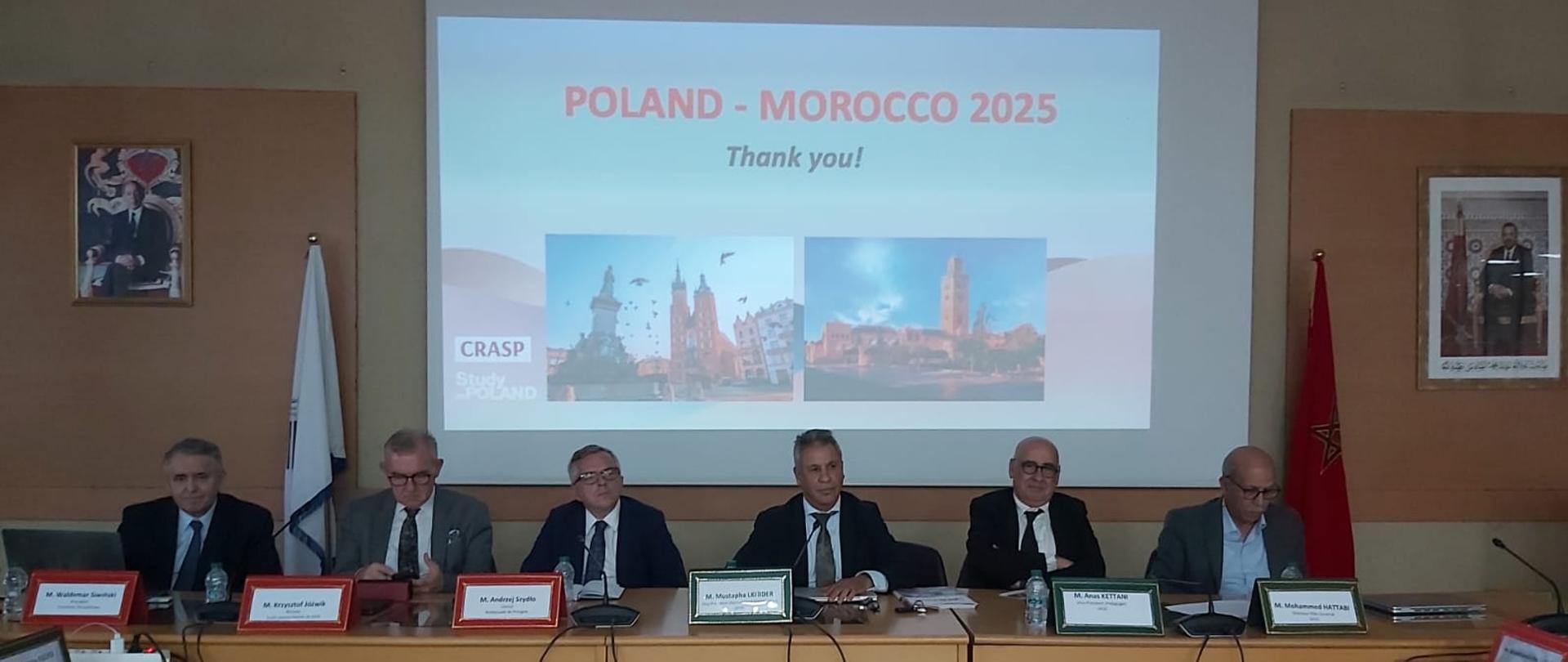 przedstawiciele polskich i marokańskich uczelni, oraz Konsul RP w Rabacie, siedzący przy stole konferencyjnym. W tle na ekranie prezentacja Polska-Maroko 2025
