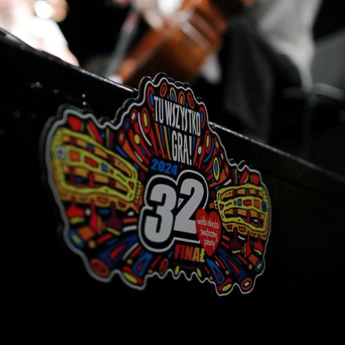 Grafika kolorowa przedstawiająca zaokrąglony kształt z logo WOŚP-u