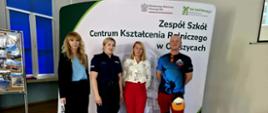 Cztery osoby pozują do wspólnego zdjęcia przed ścianką promującą Zespół Szkół Centrum Kształcenia Rolniczego w Oleszycach po zakończeniu spotkania profilaktycznego.