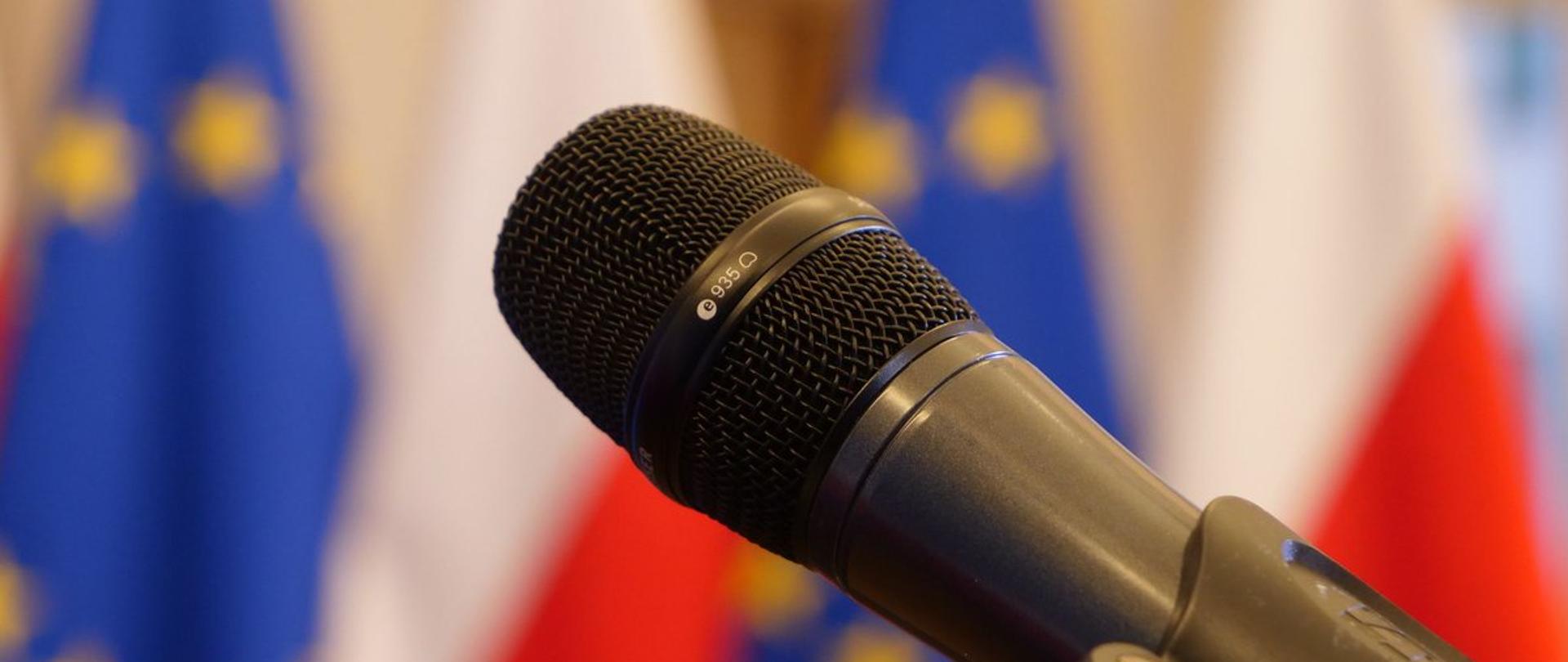 Mikrofon na statywie na tle flag