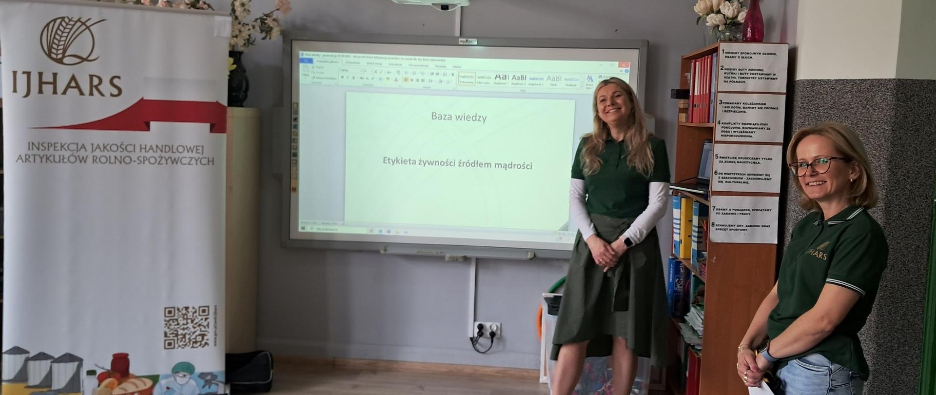 Dwie inspektorki stojące w sali lekcyjnej podczas trwającej lekcji