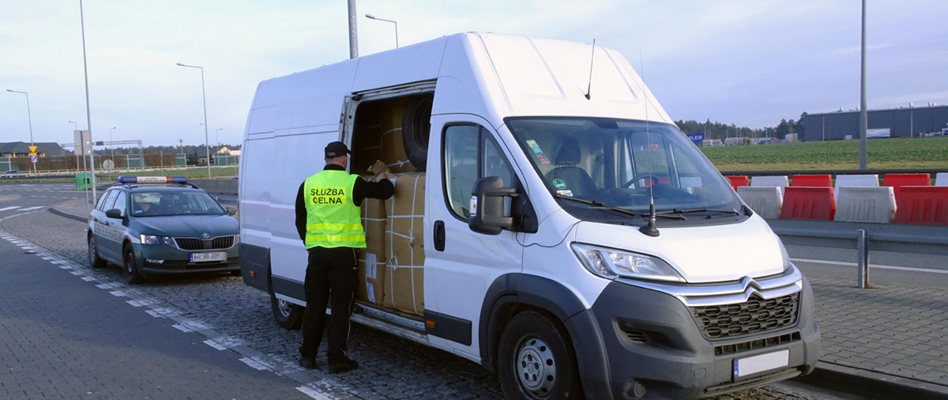 Zatrzymany na autostradzie samochód, a przy nim funkcjonariusz Służby Celno-Skarbowej