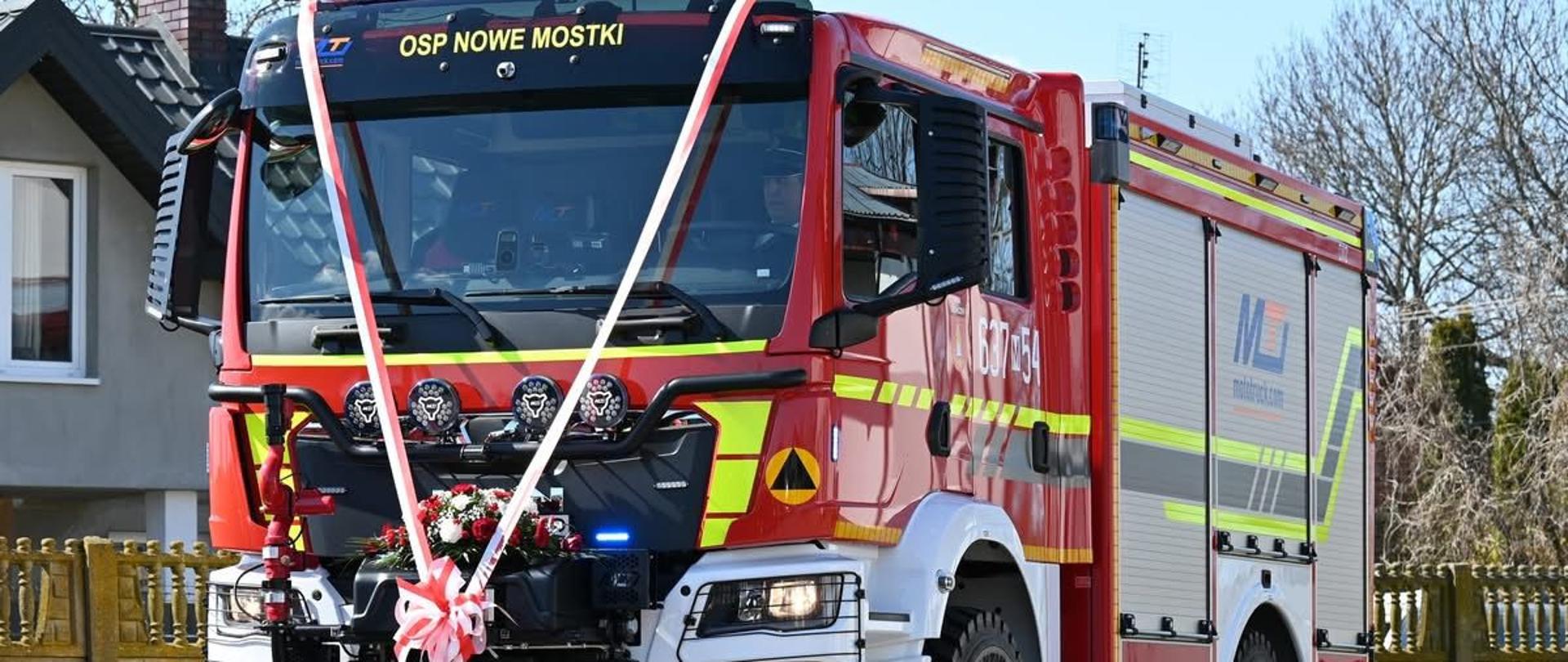 Samochód strażacki przewieszony kokardą.