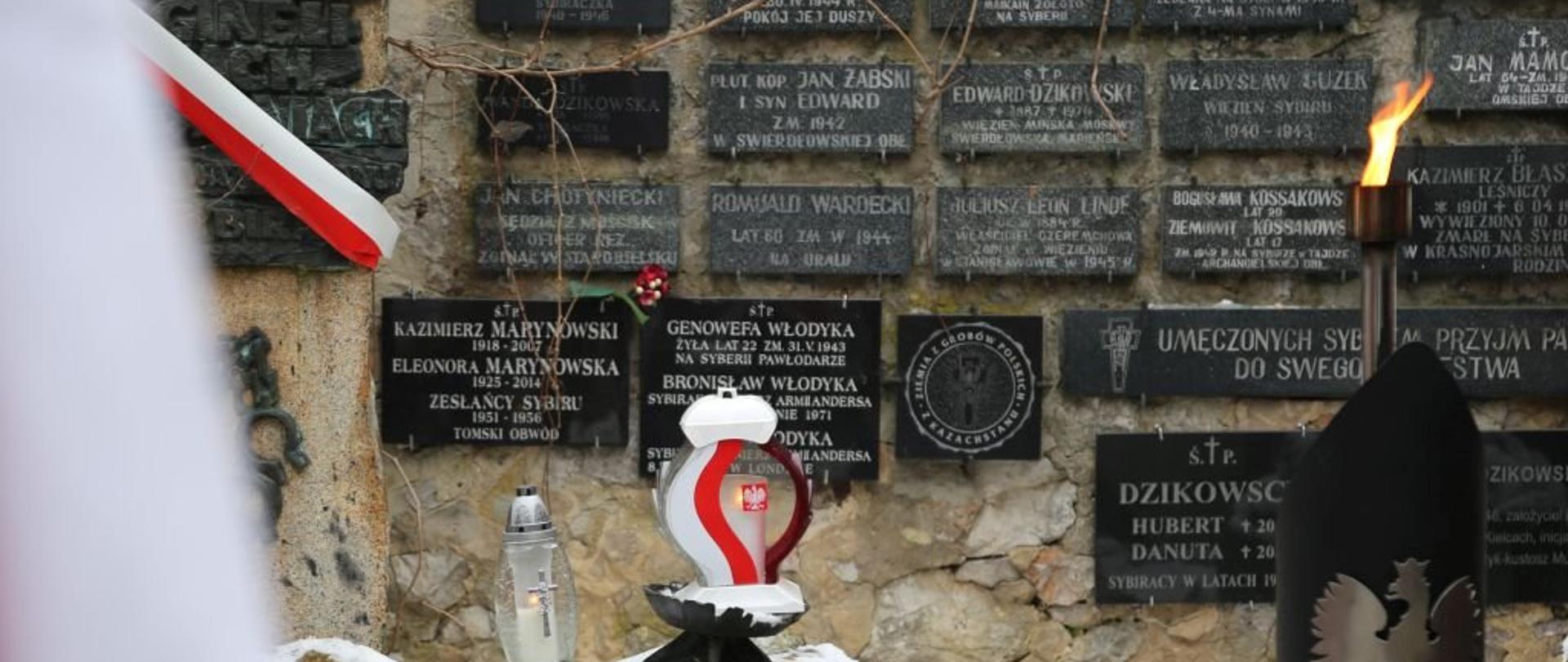 Zdjęcie przedstawia mur z tablicami upamiętniającymi Polaków deportowanych na Sybir.