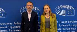 Minister Katarzyna Pełczyńska-Nałęcz i przewodniczący komisji REGI w PE Adrian-Dragoş Benea stoją, za ich plecami granatowy baner przedstawiający Parlament Europejski 
