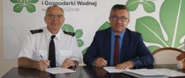 Podpisanie umowy na zakup pojazdu - komendant PSP w Zielonej Górze wraz z dyrektorem WFOŚiGW pozują do zdjęcia podpisując umowę