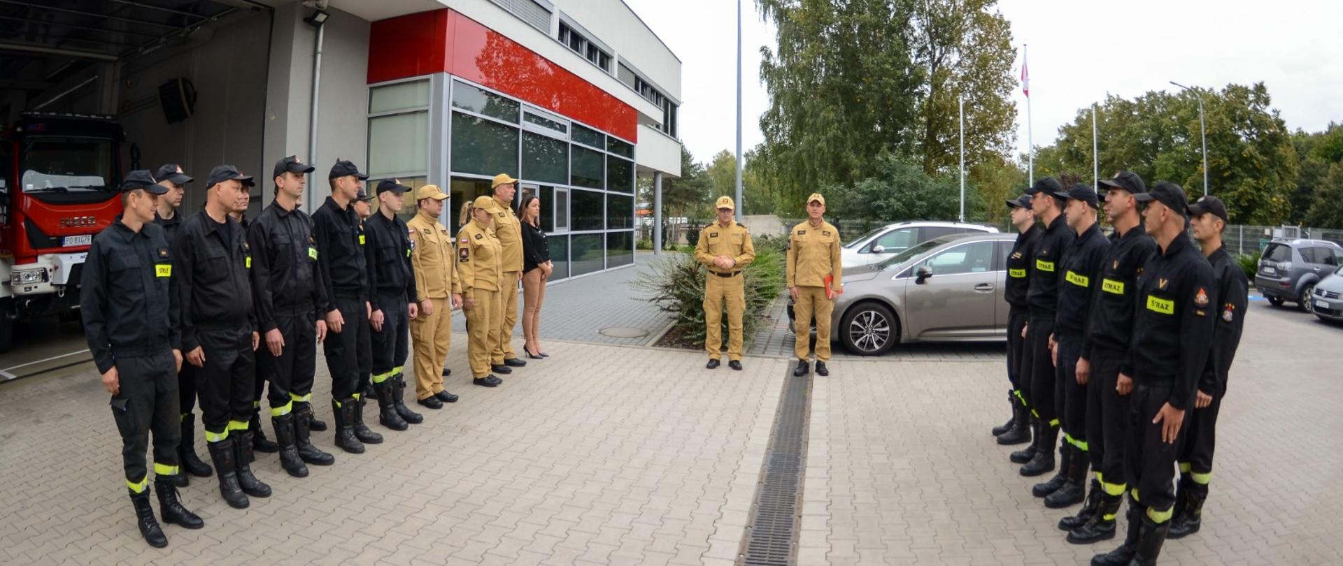 NA zdjęciu zmiany służbowe w umundurowaniu służbowym na tle komendy PSP w Śremie przed nimi komendant Powiatowy PSPw Śremie oraz D-ca JRG Śrem