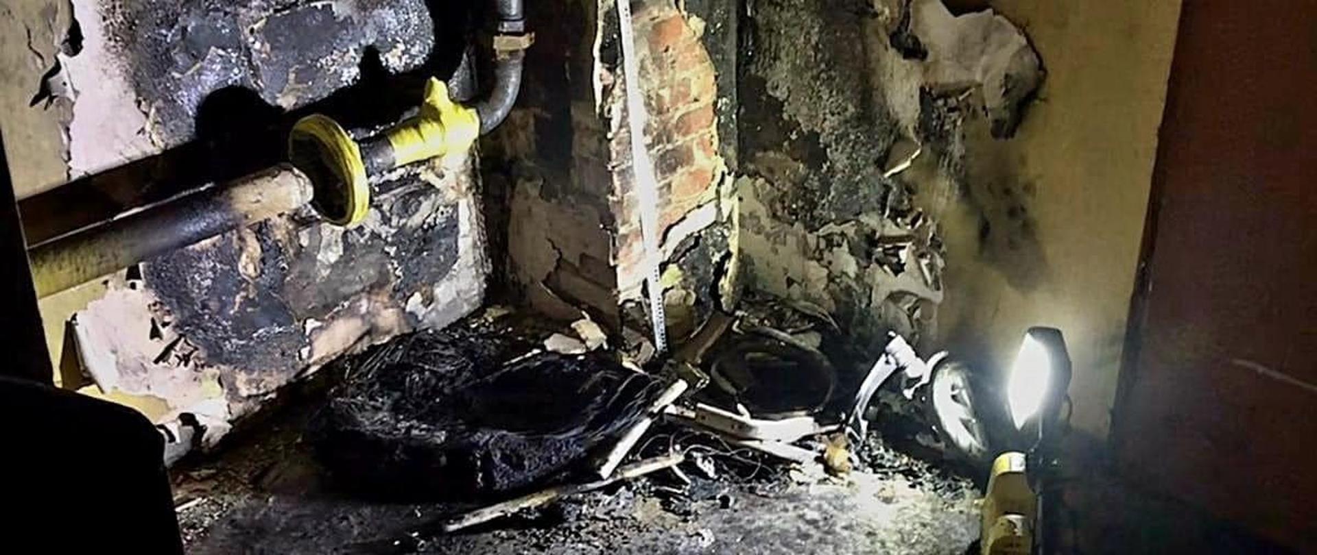 Na zdjęciu znajdują się opalone elementy instalacji gazowej oraz ściana.