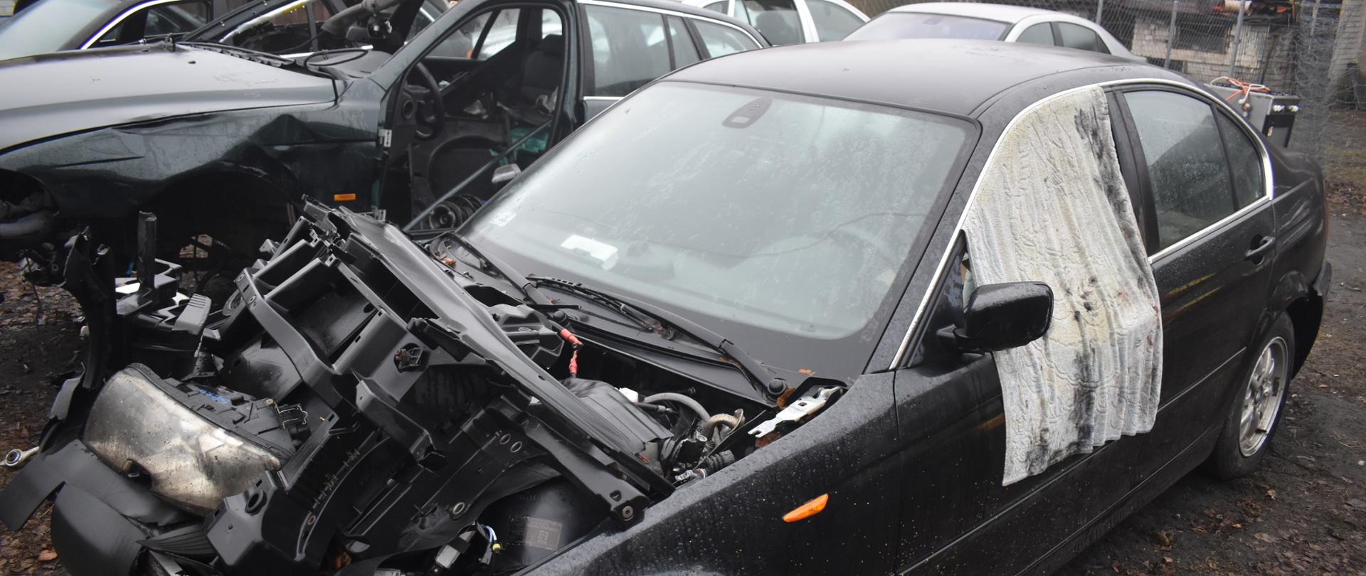 Samochody w różnym stopniu demontażu nielegalnie zgromadzone na otwartym terenie.