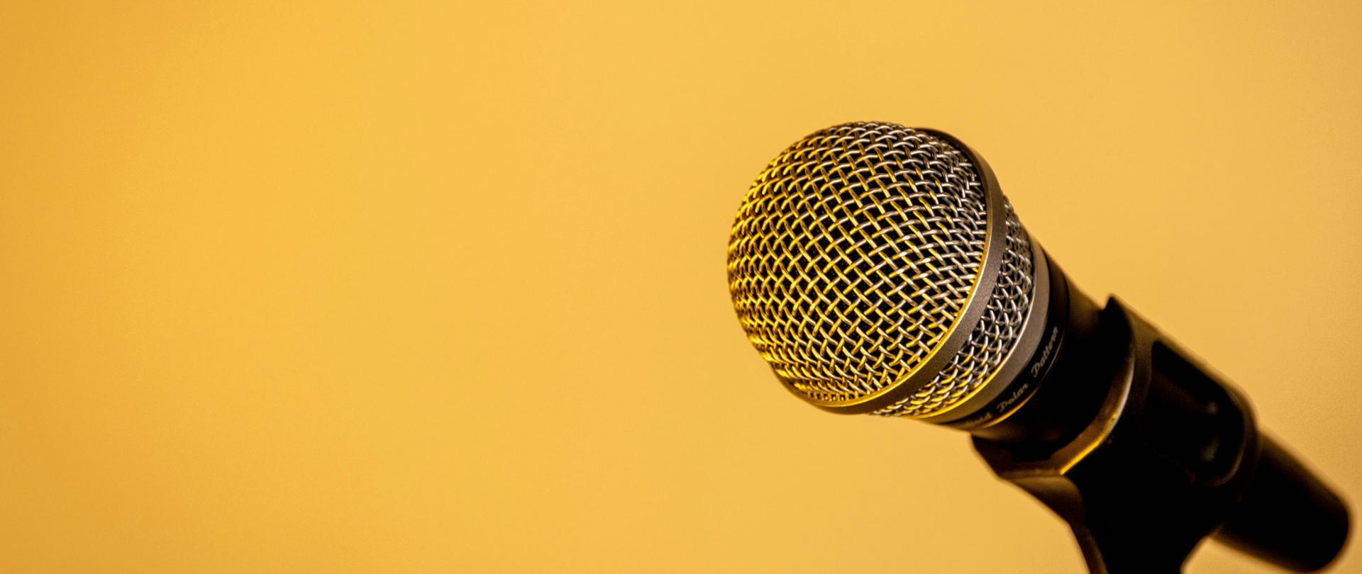 Mikrofon w statywie na żółtym tle