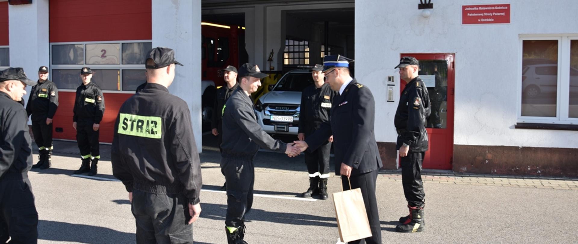 Uroczysta zmiana służby. Komendant Powiatowy PSP w Ostródzie st. bryg. Tomasz Ostrowski składający życzenia mł kpt. Dawidowi Jurczakowi