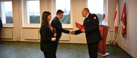 Komendant Powiatowy PSP wręcza pracownikom korpusu służby cywilnej decyzję