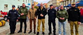 grupa oficjeli, w tym wojewoda, stoją wzdłuż drogi podczas wydarzenia, pozują do zdjęcia 