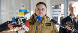 St. bryg. Krzysztof Kędryk Opolski Komendant Wojewódzki PSP w Opolu w trakcie briefingu prasowego dotyczącego punktu informacyjnego na dworcu PKP w Opolu. W tle widoczny Pan Sławomir Kłosowski Wojewoda Opolski.