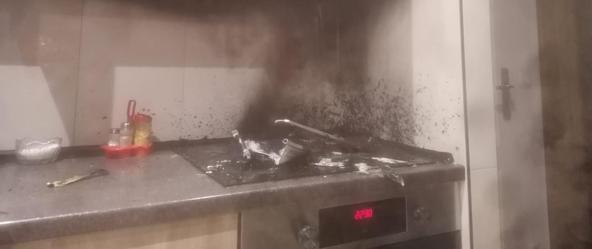 Widoczne miejsce pożaru zlokalizowane na kuchence indukcyjnej w pomieszczeniu kuchennym.