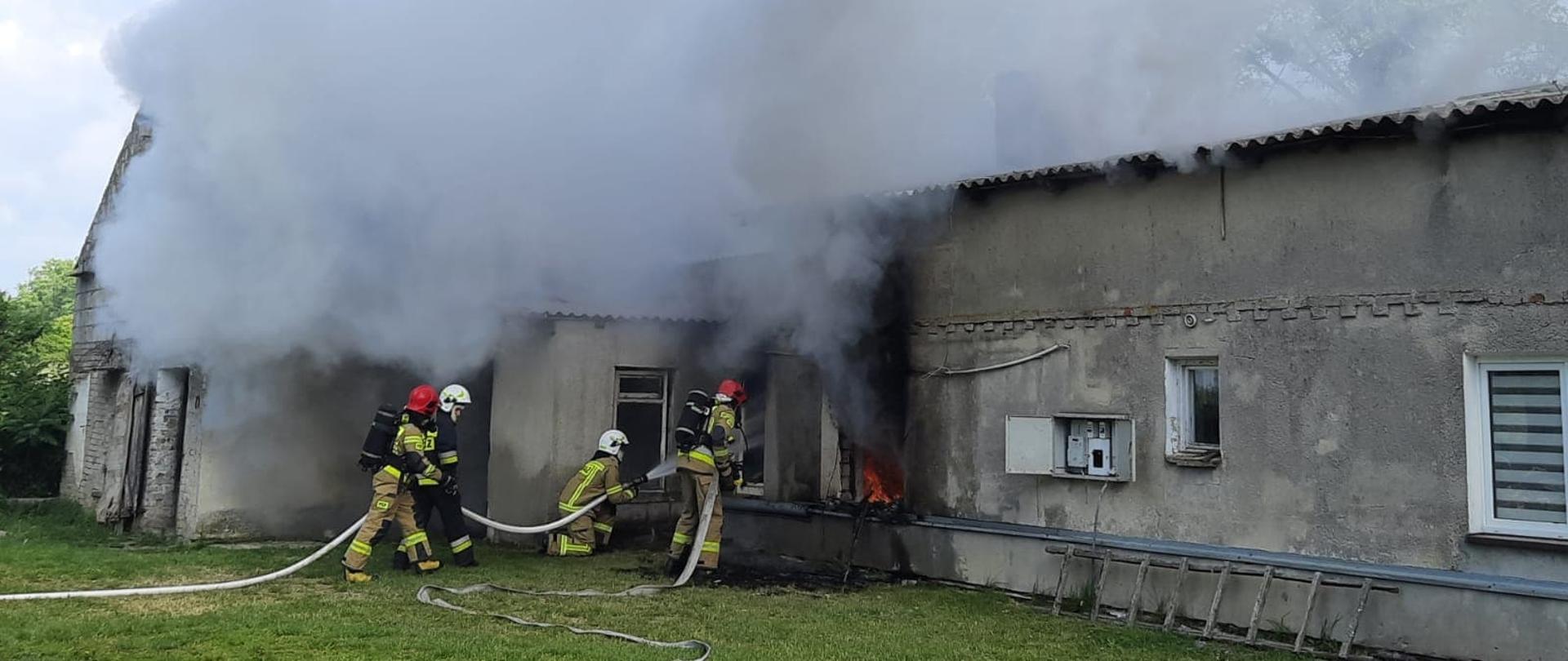 Strażacy podczas gaszenia pomieszczeń mieszkalnych. 