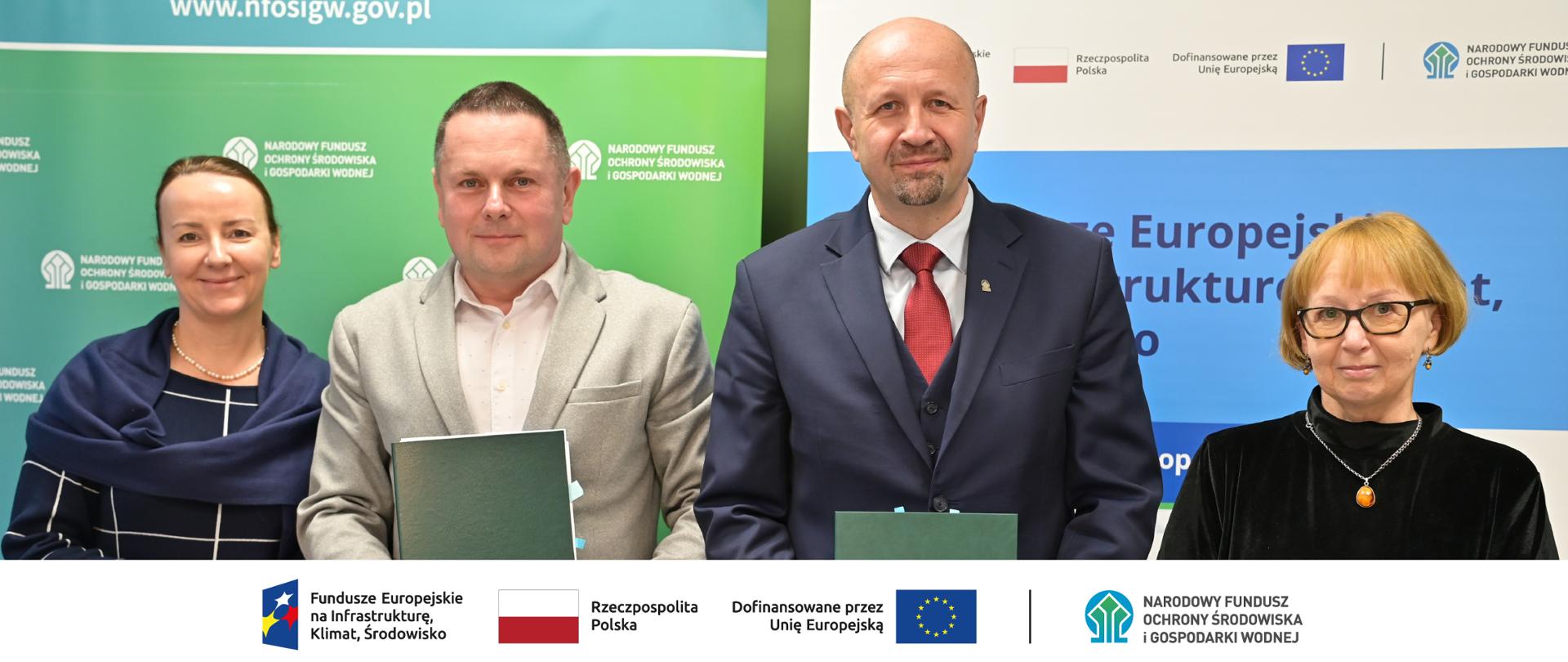 Zdjęcie grupowe.W stopce grafiki ciąg logotypów: Fundusze Europejskie na Infrastrukturę, Klimat, Środowisko, flaga Rzeczypospolita Polska, flaga UE i Dofinansowane przez UE, NFOŚiGW.