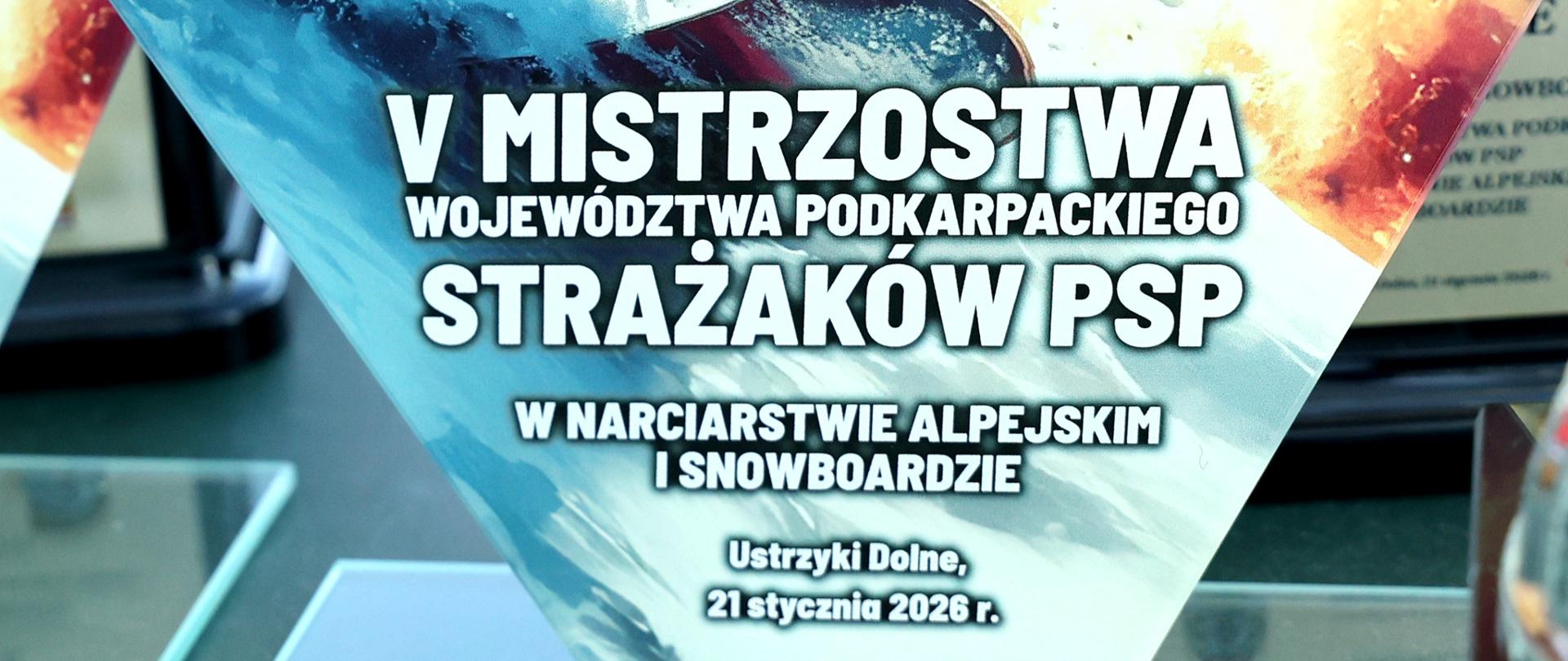 Zdjęcie przedstawia statuetkę z postacią strażaka na snowboardzie po bokach loga PSP i klubu sportowego "Strażak" a pod spodem napis: V Mistrzostwa Województwa Podkarpackiego w Narciarstwie Alpejskim i Snowboardzie.
