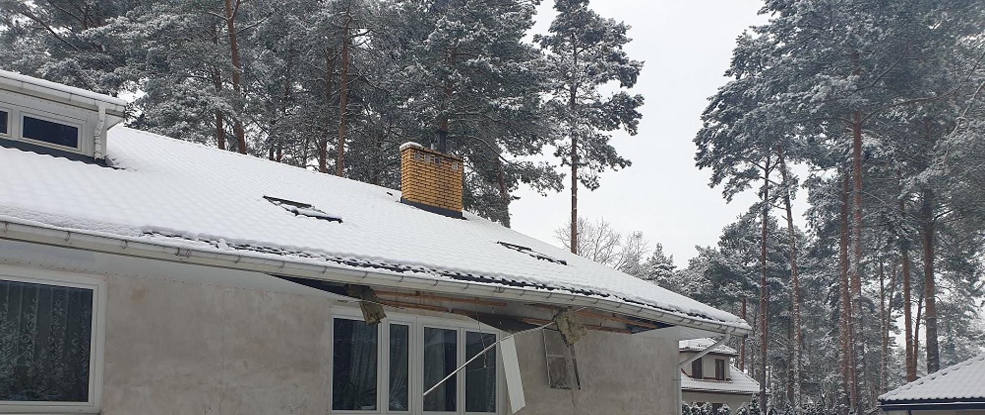 Zdjęcie przedstawia budynek ze zniszczonym częściowo dachem po wybuchu pieca C.O.