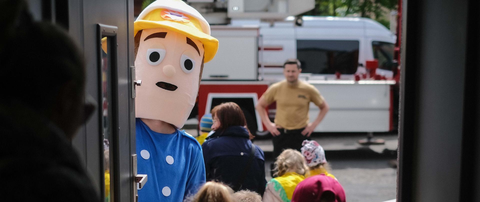 Strażak w przebraniu strażaka sama oprowadza dzieci po jednostce