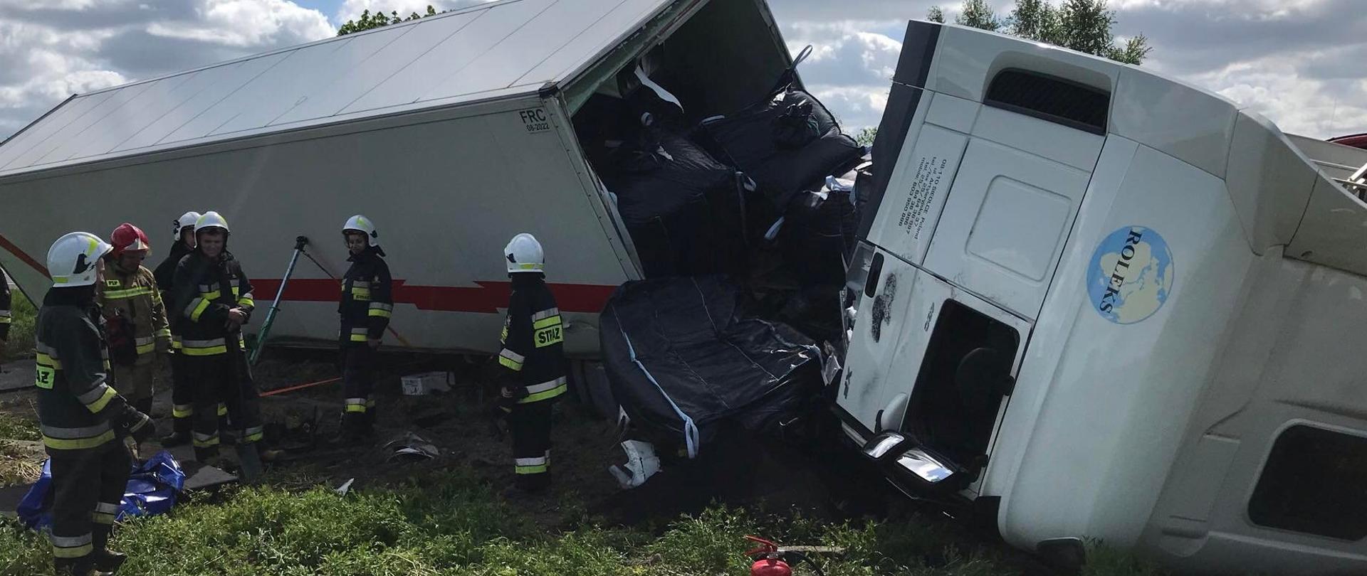 Tir w rowie, obok niego działają strażacy