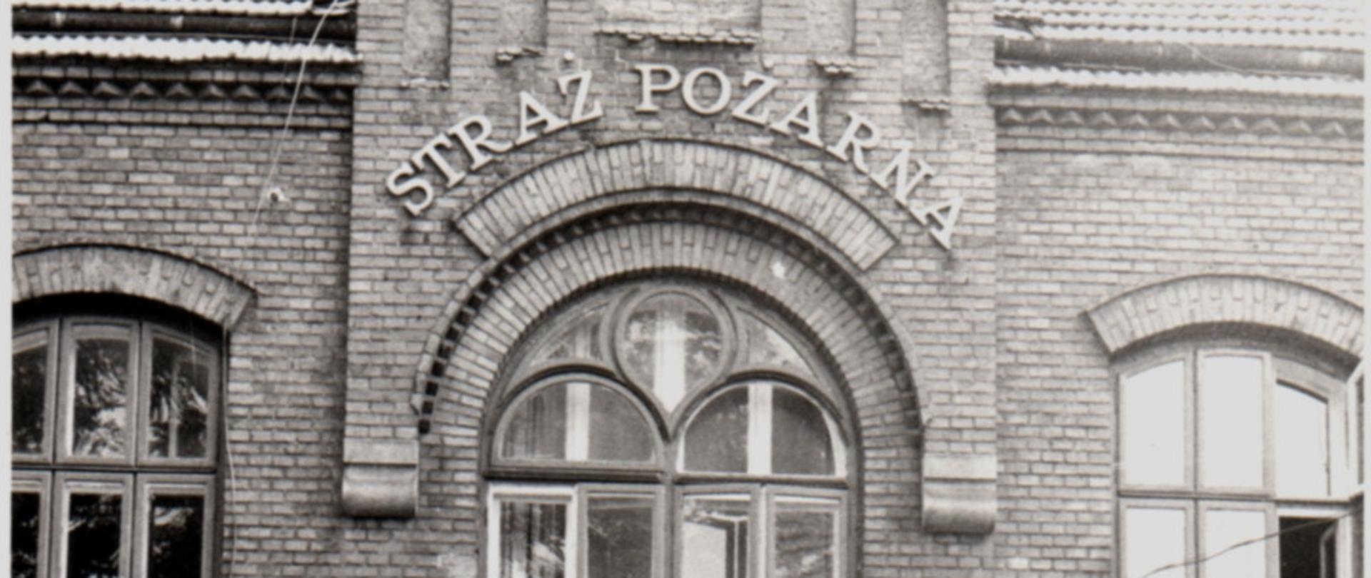 Budynek Straży Pożarnej w Żywcu na ul. Kościuszki. Przed budynkiem ustawione dwa samochody ratowniczo-gaśnicze Jelcz. Zdjęcie czarno - białe.