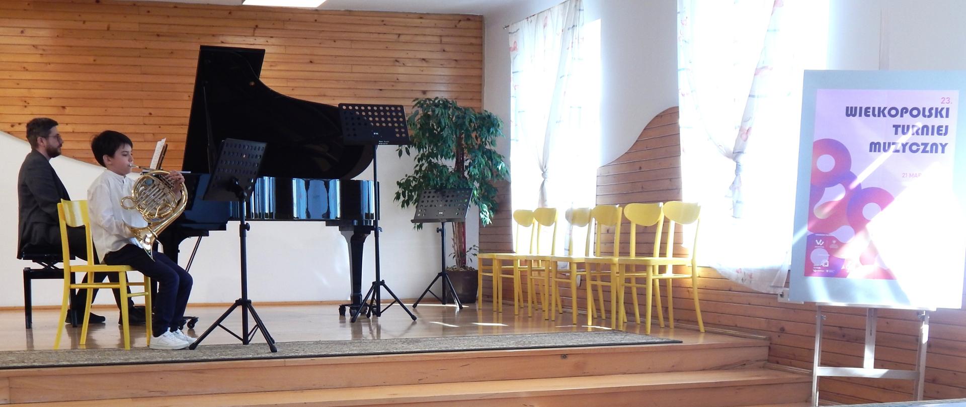 na scenie waltornista z towarzyszeniem akompaniamentu